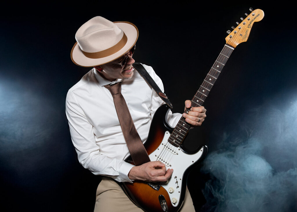 Sandy Leresche à la guitare électrique dans un halo de fumée