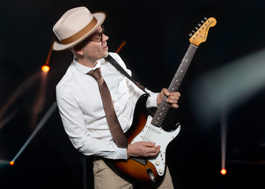Sandy Leresche en plein solo de guitare, lumières chaudes en fond
