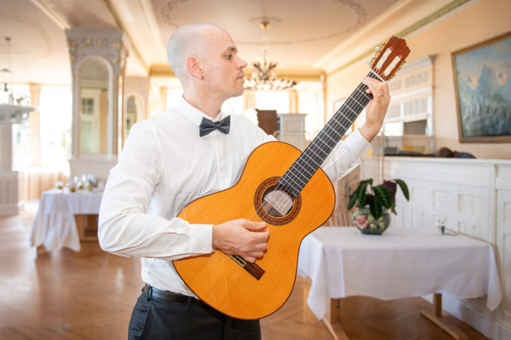 Sandy Leresche à la guitare classique dans une salle de mariage dressée